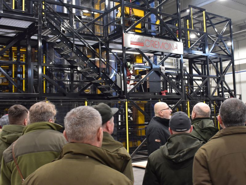 Ing. V&aacute;clavik (v strede) ukazuje lesn&iacute;kom počas exkurzie nov&uacute; lisovaciu robotick&uacute; linku v DYAS EU