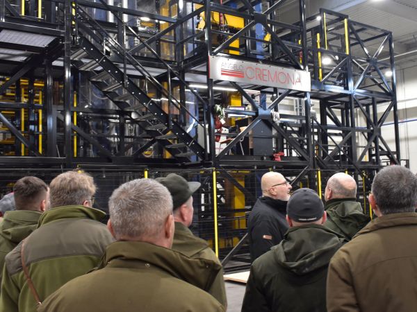 Ing. V&aacute;clavik (v strede) ukazuje lesn&iacute;kom počas exkurzie nov&uacute; lisovaciu robotick&uacute; linku v DYAS EU